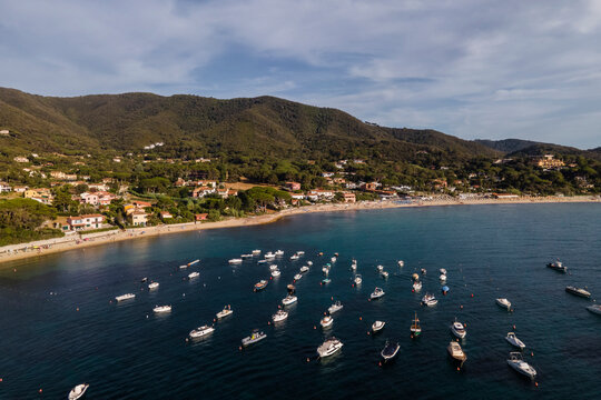 Aerial view of sailing and fishing boats docked in a small bay in Procchio near Marciana Marina, Elba Island, Italy.