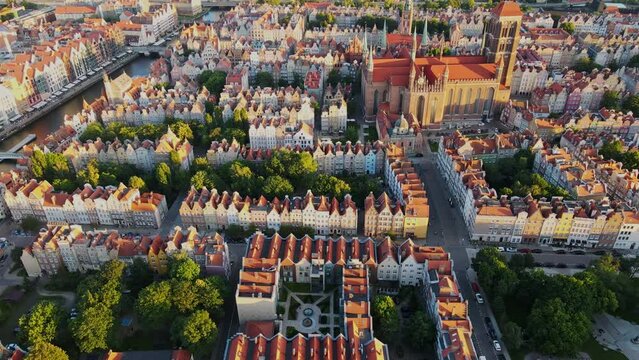 The camera flies over the center of a European city in the Netherlands. Aerial shot of red roof houses in the sunset light. High quality 4k footage