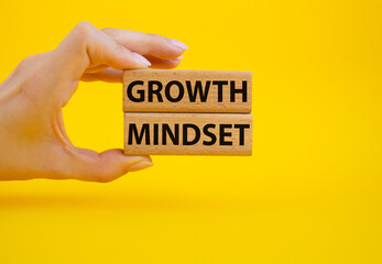 Growth Mindset symbol. Concept word Growth Mindset on wooden blocks. Beautiful yellow background. Businessman hand. Business and Growth Mindset concept. Copy space