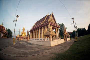 Large outdoor golden sitting Buddha and Thai Church Enshrined at Wat Thewa Prasan. Which can be clearly seen from afar Because it is located on the River and is a famous peace..