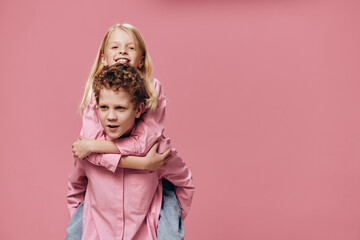 funny, happy kids brother and sister are playing and the boy is rolling the girl on his back making a funny face. Relationships, friendship, family