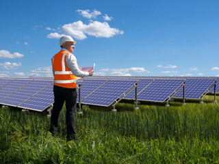 Installation of solar panels. Energy company employee. Man in orange vest in front solar panels. Concept services for installation of solar panels. Engineer oversees operation of sun power plant - obrazy, fototapety, plakaty