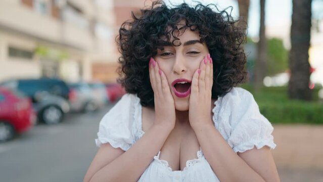Young middle east woman standing with surprise expression at street