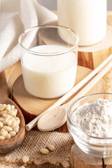Glass of cedar milk, nuts, cedar flour on wooden cuts. Vegan organic alternative milk.