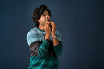 Portrait of a young man thinking on a dark background