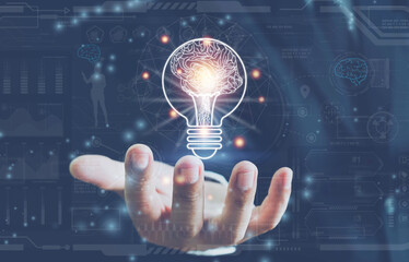 Businessman holding half of virtual lightbulb and brain on blue bokeh background , Smart thinking idea and inspiration innovation concept. creative thinking ideas and innovation concept. 