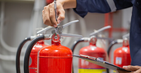 Engineer are checking and inspection a fire extinguishers tank in the fire control room for safety training and fire prevention.