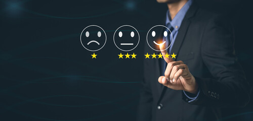 Customer Service and Satisfaction Concept Businessmen touch the virtual screen on happy smiley icons to achieve service satisfaction and feedback with excellent rated reviews.