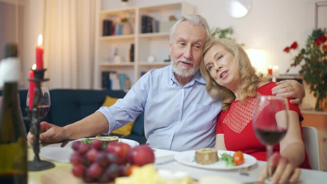 Happy couple sitting relaxed at dinner table, husband and wife, romantic date