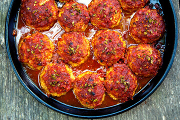 Appetizing fresh meatballs in tomato sauce. Meat dish meatballs in traditional sauce. Meatballs in tomato sauce on the table in a pan. The concept of food, home cooking, haute cuisine.