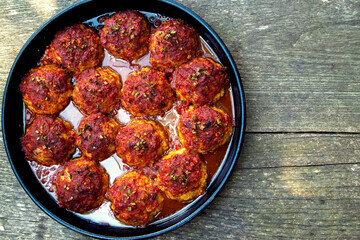 Appetizing fresh meatballs in tomato sauce. Meat dish meatballs in traditional sauce. Meatballs in tomato sauce on the table in a pan. The concept of food, home cooking, haute cuisine.