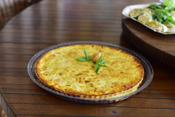 spinach and cheese quiche on wooden table
