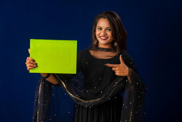 Pretty young girl posing with book on blue background
