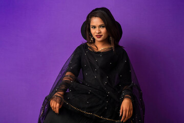 A beautiful girl sitting on an executive chair and posing.