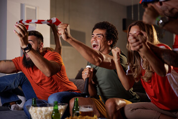 Football fans cheering while watching game on TV