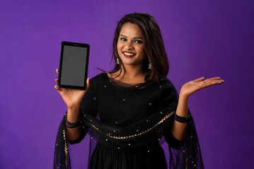 Young beautiful girl showing a blank screen of smartphone or mobile or tablet phone