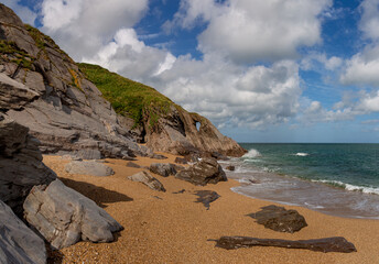 Fototapeta na wymiar Beautiful summer scene at the beach by rocks and cliffs