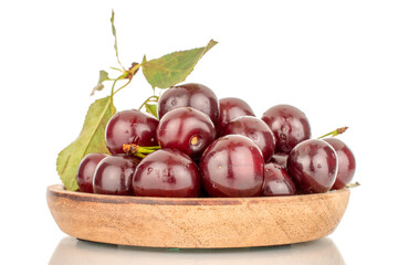 Several ripe cherries on a wooden plate, close-up, isolated on a white background.