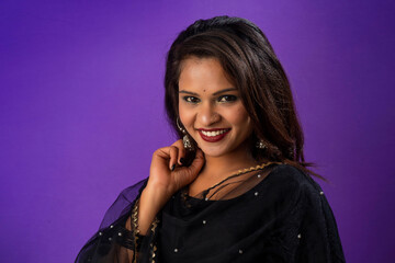 Obraz premium Portrait of a young girl or woman posing on purple background