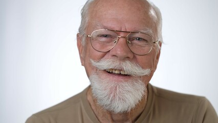 Closeup portrait of handsome old senior man laughing looking at camera against solid white background. Human emotions and facial expressions 
