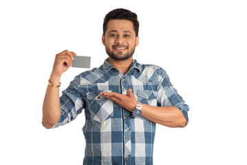 Young smiling handsome man posing with a credit or debit card on white background.