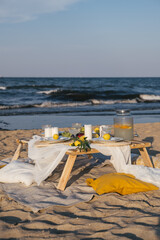 Romantic luxury picnic on the beach. Boho decoration with lemons. Bachleorette party, couple date,...