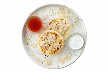 White plate with fried curd pancakes or syrniki, horizontal shot, sprinkled with almond flakes. Top view