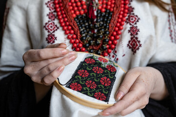 A girl embroiders a traditional Ukrainian vyshyvanka pattern - 521661868