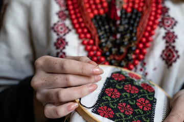 A girl embroiders a traditional Ukrainian vyshyvanka pattern - 521661869