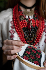 A girl embroiders a traditional Ukrainian vyshyvanka pattern - 521661870