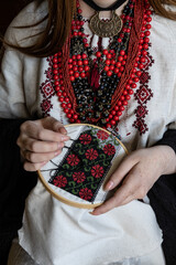 A girl embroiders a traditional Ukrainian vyshyvanka pattern - 521661872