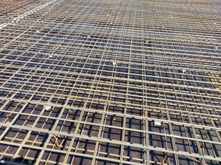 MELAKA, MALAYSIA -JULY 8, 2021: Floor slab reinforcement bar installed on timber plywood formwork. Services such as electrical conduits and water pipes are installed in it before being concreted.