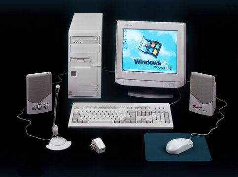 Nineties obsolete tower pc computer and Windows 95 logo on screen.