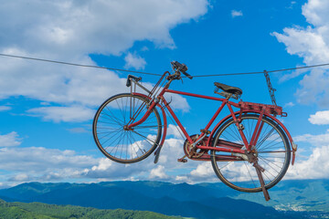 Fototapeta premium 青空の中を飛ぶ、赤い自転車