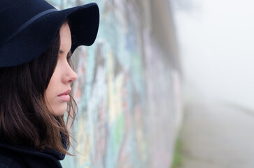 Beautiful woman in black clothes walking outdoors in a mist on autumn day