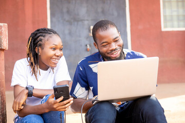 two african student using laptop computer and mobile checking assignment or school project on the...