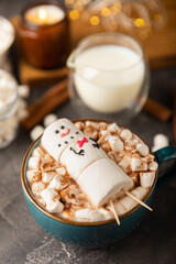 Hot chocolate mug with melted marshmallow snowman.Sweet treat for kids funny marshmallow snowman. Christmas winter holiday decoration. New Year card.Winter hot drink.