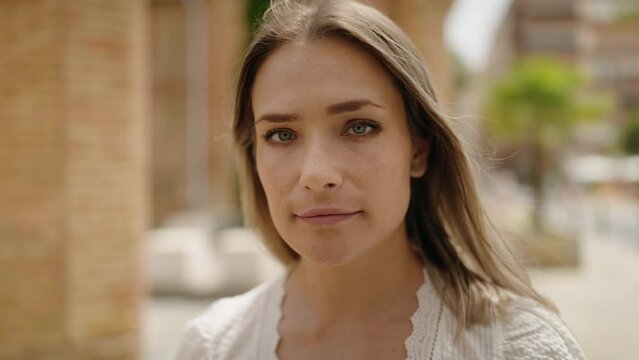 Young caucasian woman with relaxed expression standing at street