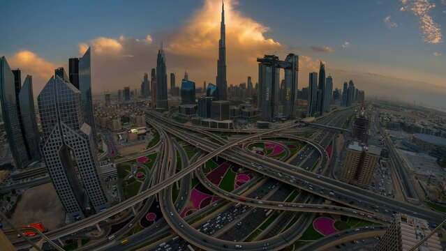 Time lapse of  car traffic in conjunction interchange high rise futuristic concept building in Dubai  from top view with wide angle.