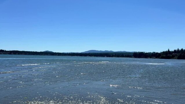 The Coast Of The Pacific Ocean On Vancouver Island, It Can Be Seen That There Was A Low Tide And Now The Calm Of The Wave Is Barely Splashing On The Amulet Calm Silence Rathtrevor Beach, Parksville.