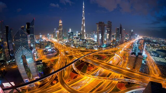 Time Lapse Of Light From Car Traffic In Interchange High Rise Futuristic Concept Building In Dubai  At Night From Top View With Wide Angle..