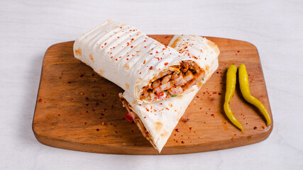 Chicken durum kebab on wooden tray. Chicken lavash doner kebab.