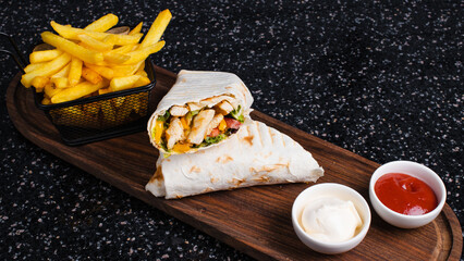 Chicken shawarma with french fries basket and mayonnaise. Chicken lavash doner kebab.