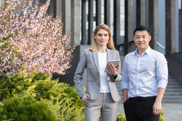Portrait of diverse business group, asian man and woman in business suits looking at camera and...