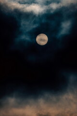 Naklejka na ściany i meble Full moon shines through dark clouds