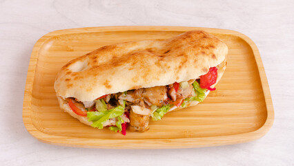 Chicken doner kebab on wooden tray top view isolated