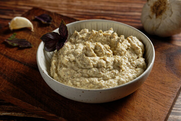 Eggplant cream with feta cheese and garlic. Served in a white bowl.