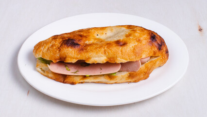 Ham sandwich in plate top view isolated
