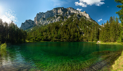 Stunning panorama view of the Green Lake with mountain Pribitz in background on a sunny summer day with blue sky cloud near the village Tragoss, Styria, Austria - 521678692
