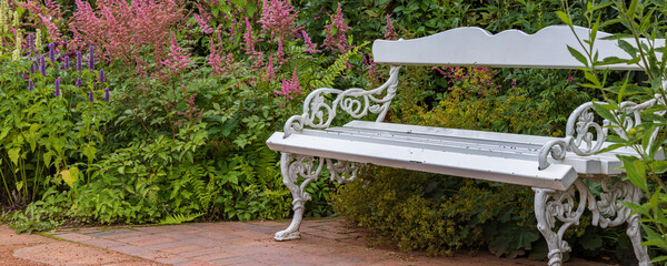 White bench in rose garden in castle park in Oldenburg in Lower Saxony in Germany Europe